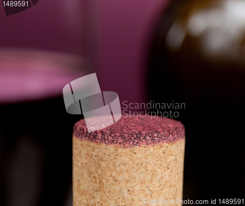 Image of Red wine soaked cork in front of glass