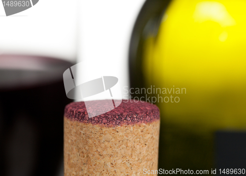 Image of Red wine soaked cork in front of glass