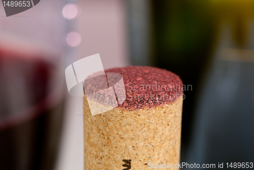 Image of Red wine soaked cork in front of glass