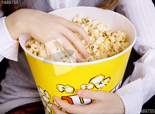 Image of hand in a bucket of popcorn