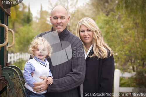 Image of Young Attractive Parents and Child Portrait in Park