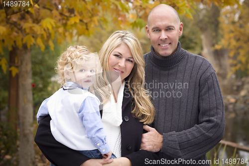 Image of Young Attractive Parents and Child Portrait in Park