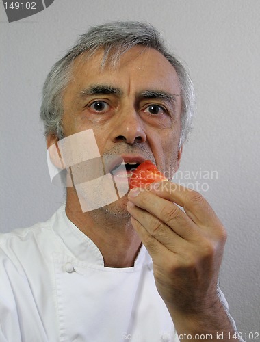 Image of The chef is eating a piece of tomato
