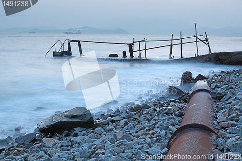 Image of old metal pipe and road to sea