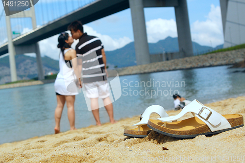 Image of modern couple kissing each other on beach 