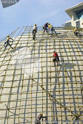 Image of Closeup of construction worker assembling scaffold on building s