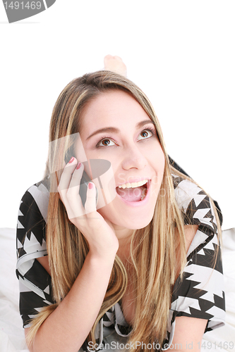 Image of Beautiful happy blond woman talking on cell phone lying down on 