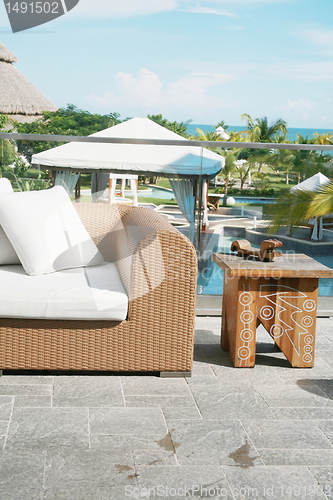 Image of Backyard with modern sofa and end table of a beautiful mansion 