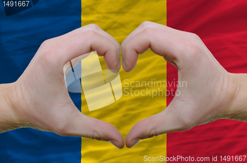 Image of Heart and love gesture showed by hands over flag of romania back