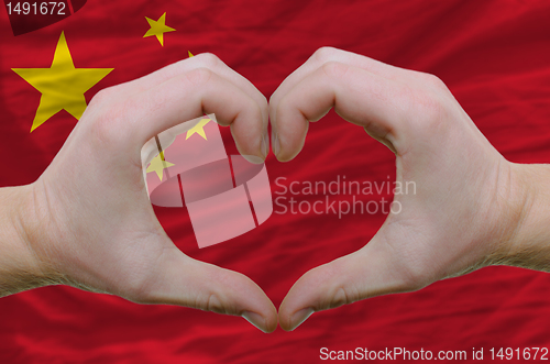 Image of Heart and love gesture showed by hands over flag of china backgr