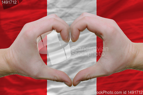 Image of Heart and love gesture showed by hands over flag of peru backgro