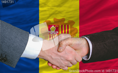 Image of businessmen handshake after good deal in front of andora flag