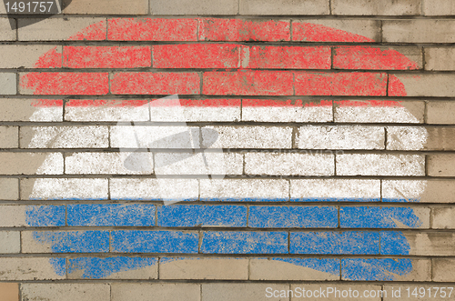 Image of flag of Netherlands on grunge brick wall painted with chalk  