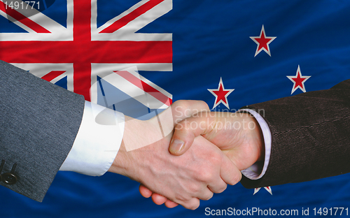 Image of businessmen handshake after good deal in front of new zealand fl