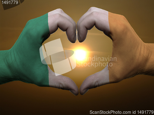Image of Heart and love gesture by hands colored in ireland flag during b