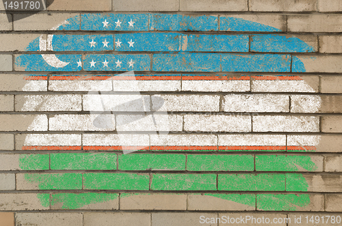 Image of flag of uzbekistan on grunge brick wall painted with chalk  