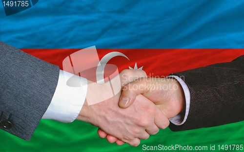 Image of businessmen handshake after good deal in front of azerbaijan fla