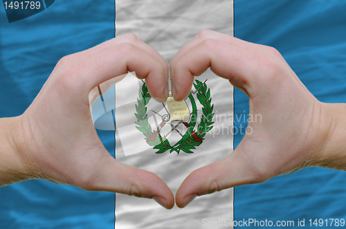 Image of Heart and love gesture showed by hands over flag of guatemala ba