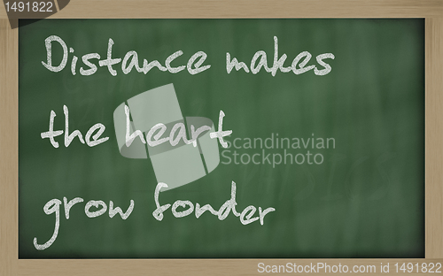 Image of " Distance makes the heart grow fonder " written on a blackboard