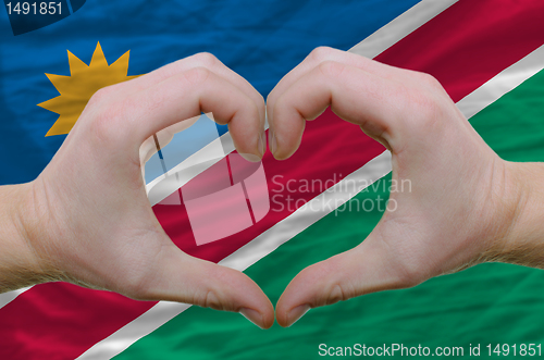 Image of Heart and love gesture showed by hands over flag of namibia back