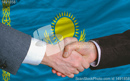 Image of businessmen handshake after good deal in front of kazakhstan fla