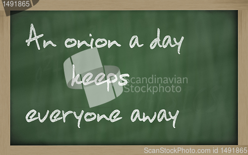 Image of " An onion a day keeps everyone away " written on a blackboard