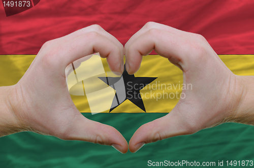 Image of Heart and love gesture showed by hands over flag of ghana backgr