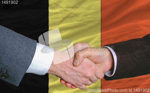 Image of businessmen handshakeafter good deal in front of belgium flag