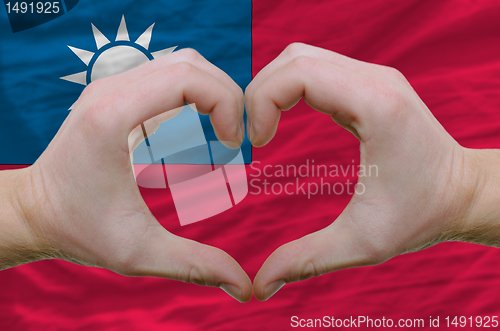 Image of Heart and love gesture showed by hands over flag of taiwan backg