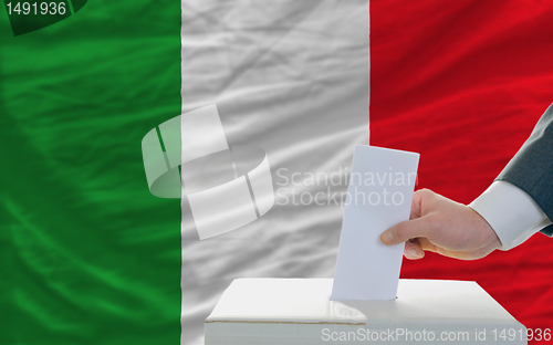 Image of man voting on elections in italy in front of flag