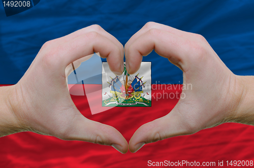 Image of Heart and love gesture showed by hands over flag of haiti backgr