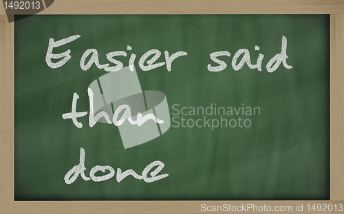 Image of " Easier said than done " written on a blackboard