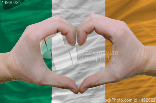 Image of Heart and love gesture showed by hands over flag of ireland back