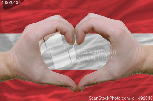 Image of Heart and love gesture showed by hands over flag of Austria back