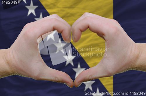 Image of Heart and love gesture showed by hands over flag of bosnia herze