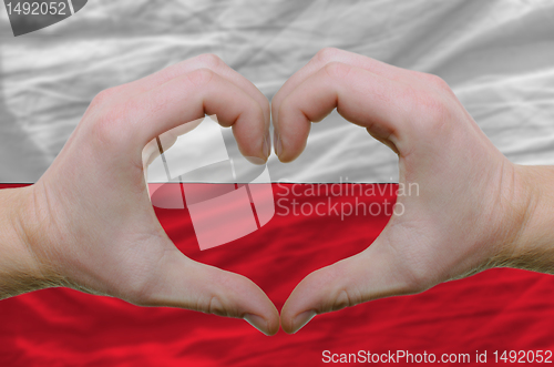 Image of Heart and love gesture showed by hands over flag of poland backg