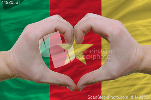 Image of Heart and love gesture showed by hands over flag of cameroon bac