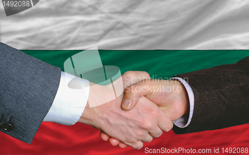 Image of businessmen handshake after good deal in front of bulgaria flag