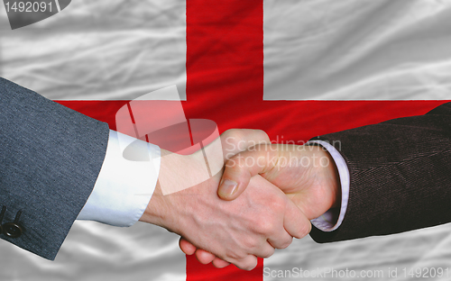 Image of businessmen handshake after good deal in front of england flag