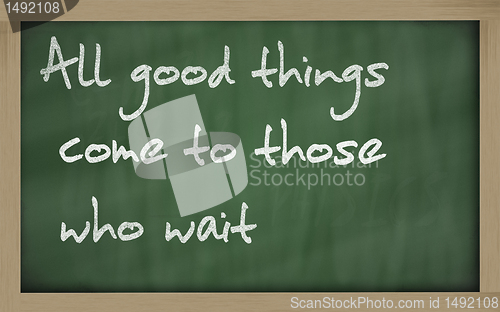 Image of " All good things come to those who wait " written on a blackboa