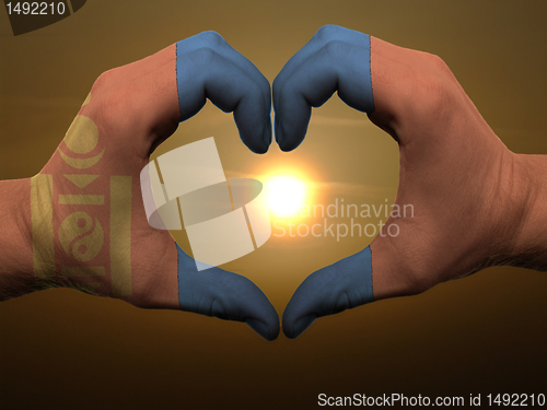 Image of Heart and love gesture by hands colored in mongolia flag during 
