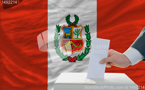 Image of man voting on elections in peru in front of flag