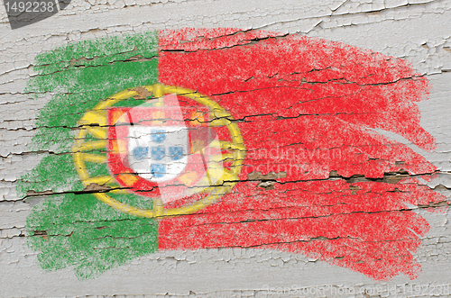 Image of flag of Portugal on grunge wooden texture painted with chalk  