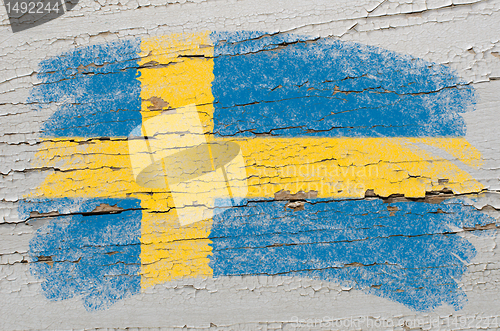 Image of flag of Sweden on grunge wooden texture painted with chalk  