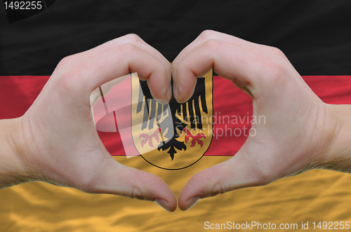 Image of Heart and love gesture showed by hands over flag of germany back