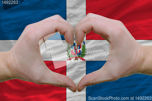 Image of Heart and love gesture showed by hands over flag of dominican re