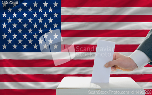 Image of man voting on elections in america in front of flag