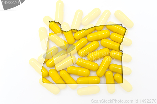 Image of Outline map of oregon with transparent pills in the background