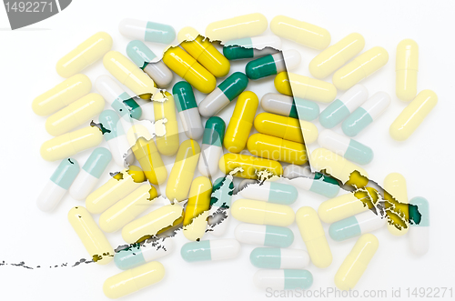 Image of Outline Alaska map of with transparent pills in the background