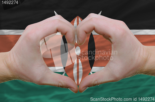 Image of Heart and love gesture showed by hands over flag of kenya backgr